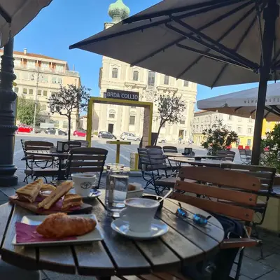 a wooden table with bread and coffee and an umbrella at Josef apartment, CENTER in Solkan