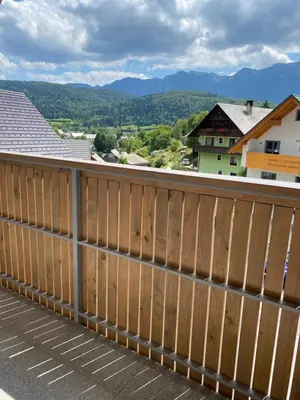 a wooden fence on a balcony with mountains in the background at Lux in Bohinj in Bohinj