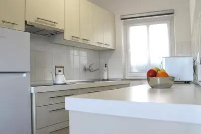 a white kitchen with a bowl of fruit on a counter at Apartma Helena in Ajdovščina