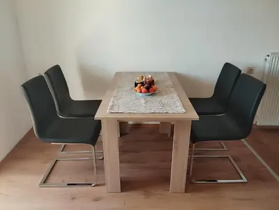 a table with four chairs and a bowl of fruit on it at Apartma Helena in Ajdovščina