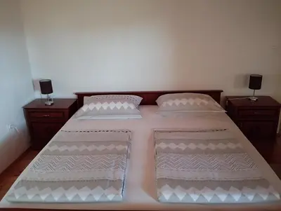 a bedroom with a bed with two night stands at Apartma Helena in Ajdovščina