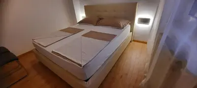 a white bed in a room with a light at Apartma Helena in Ajdovščina