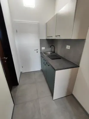 a small kitchen with white cabinets and a sink at Sleep&Go Vrtojba International Border Crossing in Šempeter pri Gorici