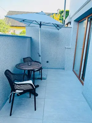 a patio with a table and chairs and an umbrella at Apartma Neja in Žirovnica