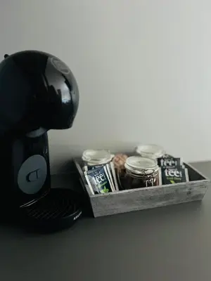 a black coffee maker with a tray of toothpaste and cans at Apartma Neja in Žirovnica
