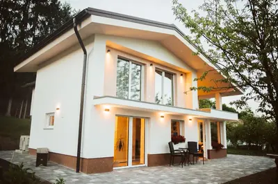 a small white house with a lot of windows at Holiday Home Vinagora in Bistrica ob Sotli