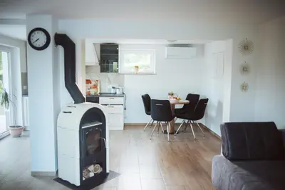 a living room with a fireplace and a kitchen at Holiday Home Vinagora in Bistrica ob Sotli