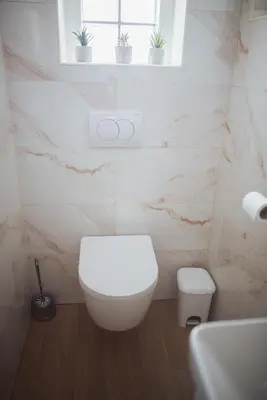 a white bathroom with a toilet and a window at Holiday Home Vinagora in Bistrica ob Sotli