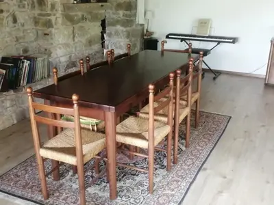 a wooden table with chairs and a piano at Silentium Domus doo in Gornje Vreme