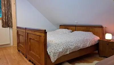 a bedroom with a wooden bed with a wooden dresser at Pr Trnovc in Preddvor