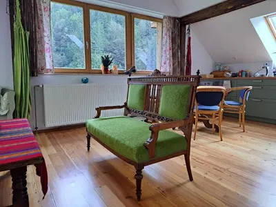 a living room with a green chair and a table at Pr Trnovc in Preddvor