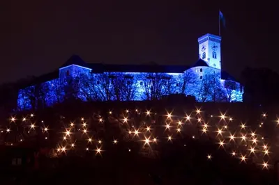 a blue building with a clock tower at night at Your Ljubljana Home in Ljubljana