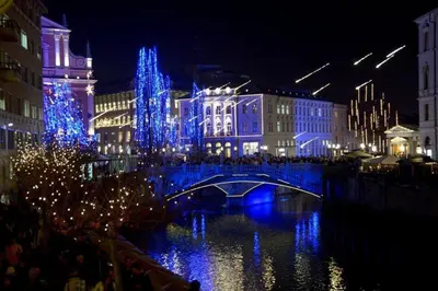 a bridge over a river in a city at night at Your Ljubljana Home in Ljubljana