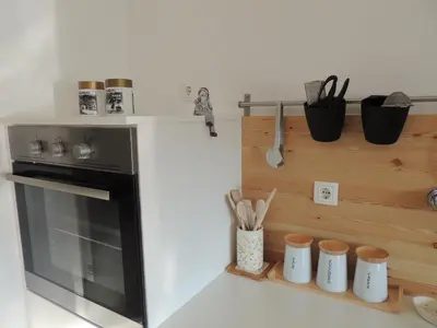 a kitchen with a stove and a shelf with utensils at Your Ljubljana Home in Ljubljana