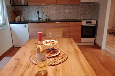 a bottle of wine and a plate of food on a table at Simona's place-Free private parking in Ljubljana