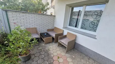 a patio with three chairs and a window at Simona's place-Free private parking in Ljubljana