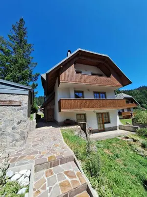 a house with a stone walkway in front of it at Sunrise Apartment in Rateče