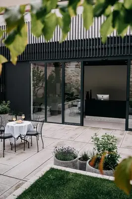 a patio with a table and chairs in front of a building at Villa Elizabeth - Apartment with Garden in Slovenj Gradec