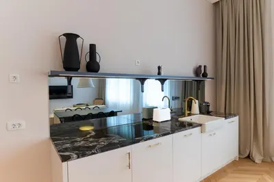 a kitchen with white cabinets and a black counter top at Villa Elizabeth - Apartment with Garden in Slovenj Gradec