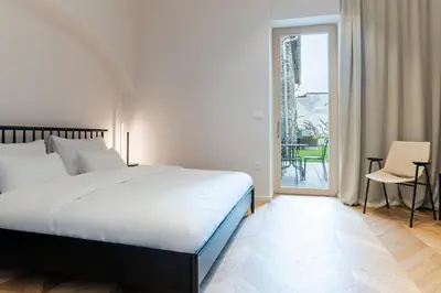 a bedroom with a large bed and a balcony at Villa Elizabeth - Apartment with Garden in Slovenj Gradec