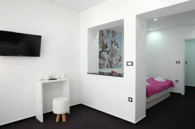 a bedroom with a bed and a tv on a wall at Luwiana Suites in Ljubljana