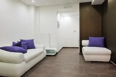 a living room with a white couch and purple pillows at Luwiana Suites in Ljubljana