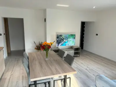 a dining room with a table with a vase of flowers on it at Livan Apartment in Tolmin