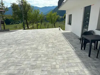 a patio with a table and a table and a building at Livan Apartment in Tolmin
