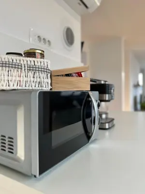 a microwave sitting on a kitchen counter with some wooden sidx at Aura Apartments in Žirovnica