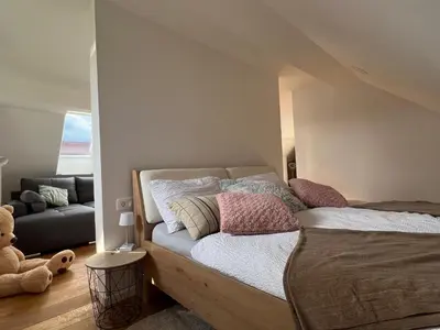 a bedroom with a bed and a teddy bear at Aura Apartments in Žirovnica