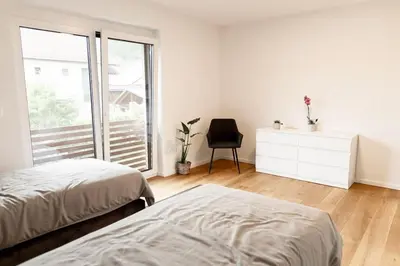 a bedroom with two beds and a desk and a chair at Aura Apartments in Žirovnica