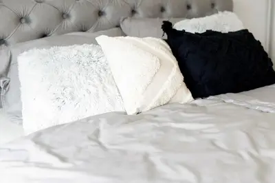 a bed with white sheets and pillows on it at Aura Apartments in Žirovnica