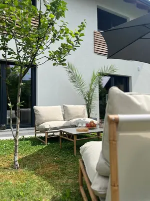 a patio with couches and a table and a tree at Aura Apartments in Žirovnica