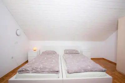 two beds in a room with a white ceiling at Apartment Harmony Bled in Bled