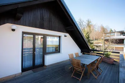 a deck with a table and chairs on a house at Apartment Harmony Bled in Bled