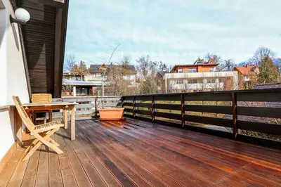 a wooden deck with a table and chairs on a balcony at Apartment Harmony Bled in Bled