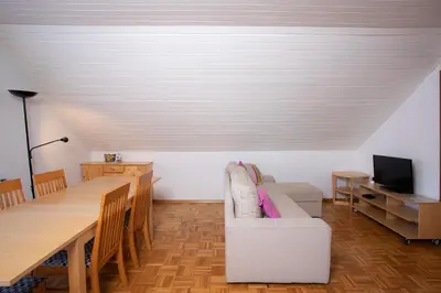a dining room with a table and a white couch at Apartment Harmony Bled in Bled
