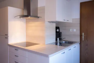 a kitchen with white cabinets and a sink at Apartment Harmony Bled in Bled