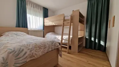 a bedroom with a bunk bed and a bunk ladder at Apartma Kofol in Kobarid