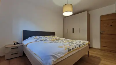 a bedroom with a large bed and a night stand at Apartma Kofol in Kobarid
