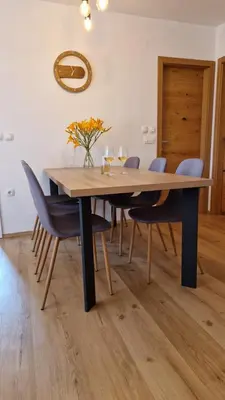 a dining room with a wooden table and chairs at Apartma Kofol in Kobarid