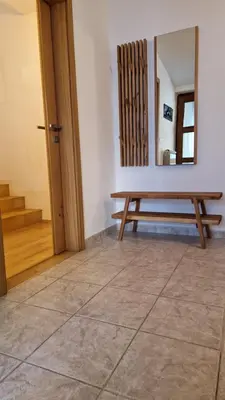 a wooden bench in a room with a mirror at Apartma Kofol in Kobarid