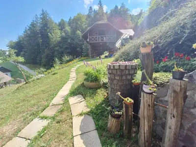 a garden with a fence with potted plants and a building at Apartma Slovenias in Škofja Loka