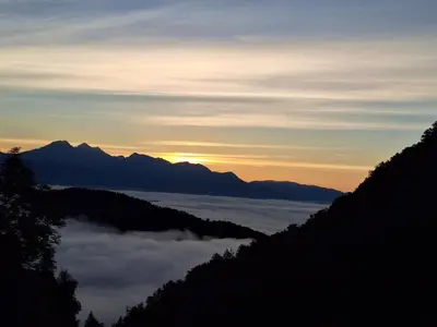 a view of the sun rising over a valley of clouds at Apartma Slovenias in Škofja Loka