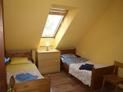 two beds in a room with a window at Apartment VISOTA in Ptuj