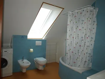 a bathroom with a toilet and a sink and a window at Apartment VISOTA in Ptuj