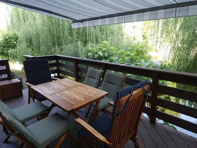 a wooden table and chairs on a deck at Apartment Kostanjevica na Krki in Kostanjevica na Krki