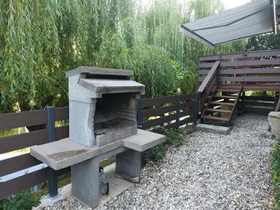 a stone oven sitting next to a wooden fence at Apartment Kostanjevica na Krki in Kostanjevica na Krki
