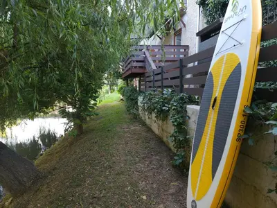 a surfboard leaning against a wall next to a house at Apartment Kostanjevica na Krki in Kostanjevica na Krki