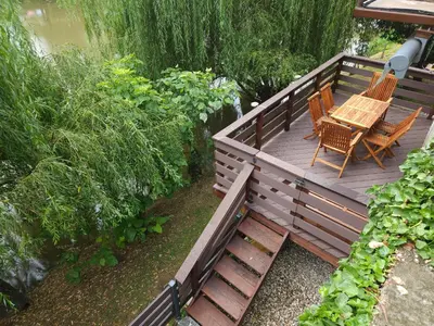 a wooden deck with two chairs and a table at Apartment Kostanjevica na Krki in Kostanjevica na Krki